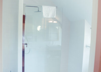 Salle de bain moderne sous comble avec une douche à l'italienne.