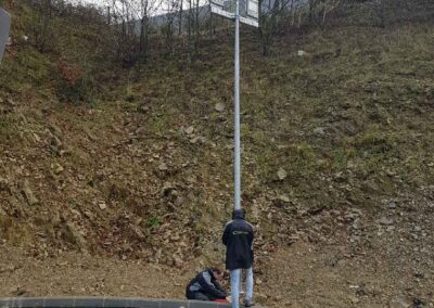Trois techniciens travaillent à l'installation d'un lampadaire.