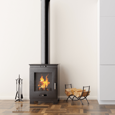 Un poêle à bois noir contemporain avec des flammes visibles, installé dans un salon au parquet en bois. Un porte-bûches rempli et des accessoires de cheminée sont placés à côté.