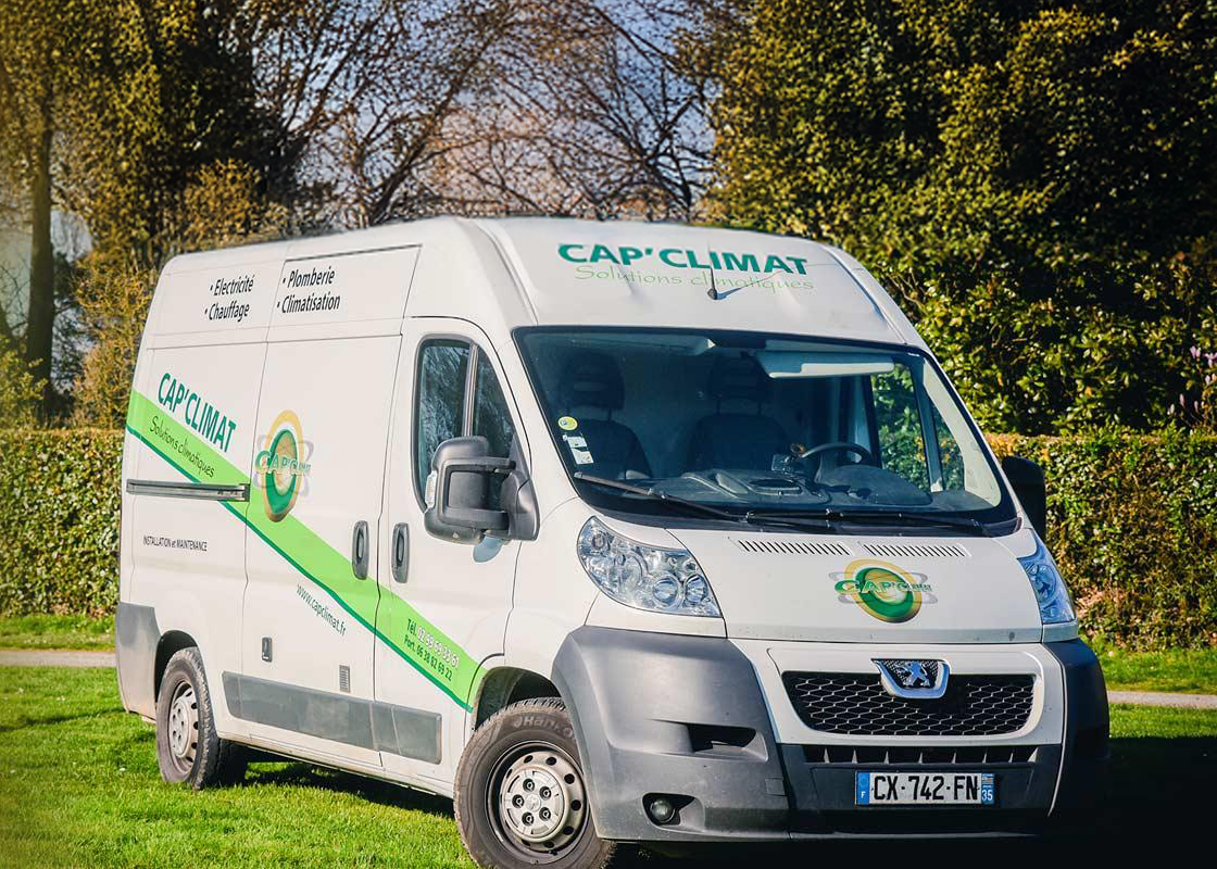 Véhicule d'intervention blanc floqué CAP'CLIMAT stationné en extérieur. Le marquage indique les prestations : Électricité, Plomberie, Chauffage et Climatisation.